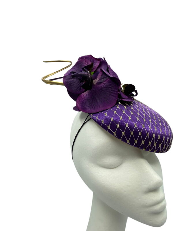 Stunning purple headpiece with matching orchid flower detail and finished with a gold veiling overlay on the base.